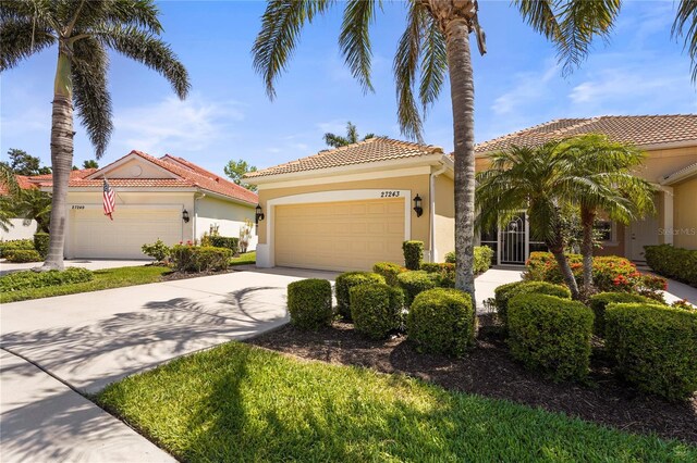 27243 Ipswich Dr, Englewood, FL 34223 - mediterranean / spanish-style home with a garage, stucco siding, a tile roof, and concrete driveway