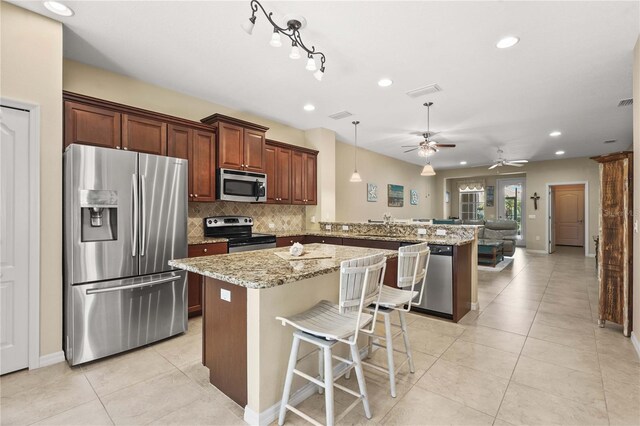 27243 Ipswich Dr, Englewood, FL 34223 - kitchen featuring ceiling fan, appliances with stainless steel finishes, a peninsula, recessed lighting, and decorative backsplash