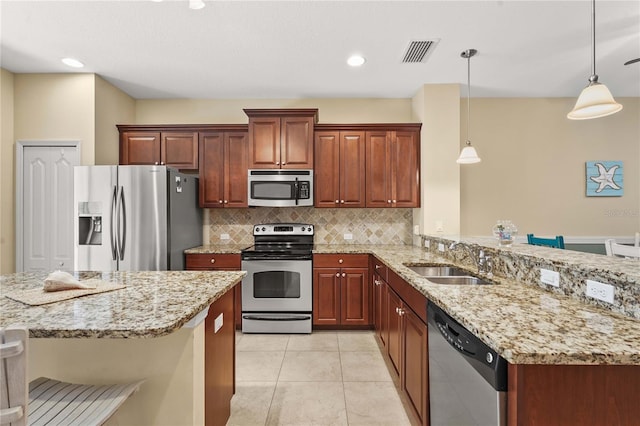 27243 Ipswich Dr, Englewood, FL 34223 - kitchen with a sink, stainless steel appliances, a peninsula, backsplash, and visible vents