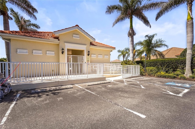 27243 Ipswich Dr, Englewood, FL 34223 - view of front of house with uncovered parking, stucco siding, a tiled roof, and fence