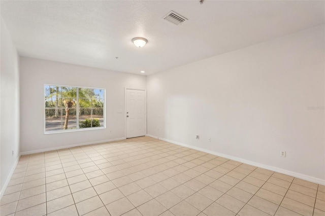 unfurnished room featuring baseboards and visible vents