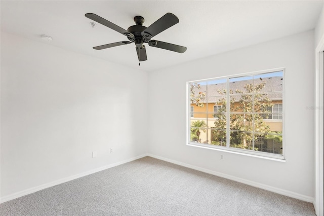 carpeted spare room with baseboards and ceiling fan