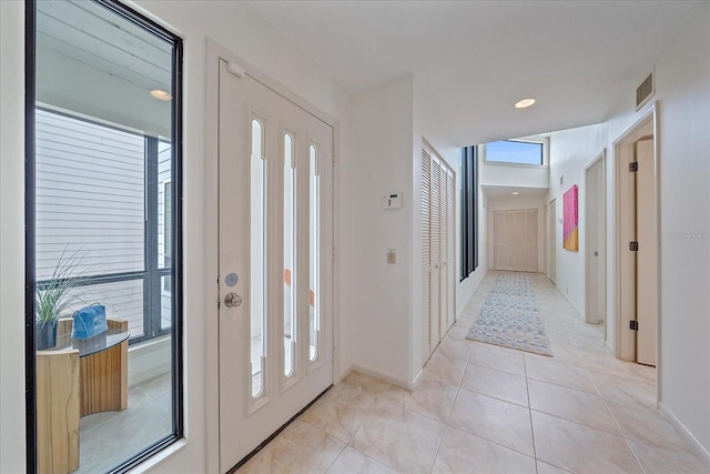 foyer featuring baseboards and light tile patterned floors