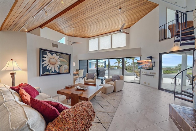 living area with ceiling fan, wood ceiling, tile patterned floors, high vaulted ceiling, and beam ceiling
