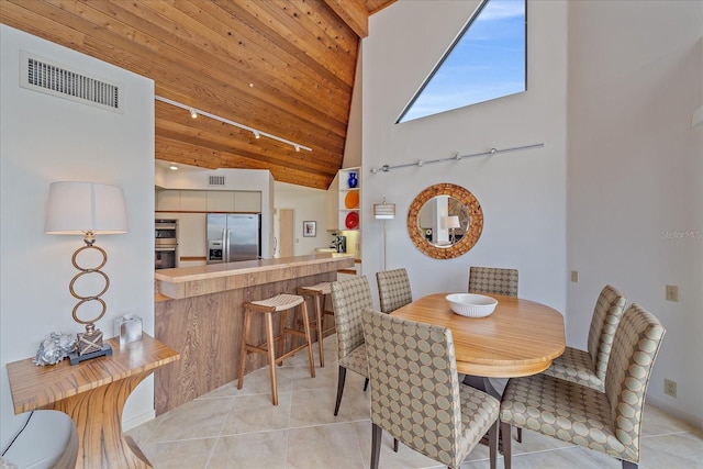 dining area with track lighting, high vaulted ceiling, light tile patterned flooring, and wood ceiling
