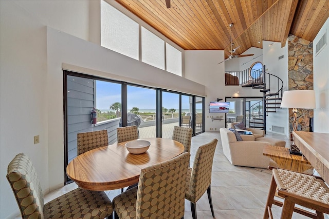 dining room with wood ceiling, high vaulted ceiling, a ceiling fan, stairway, and light tile patterned floors