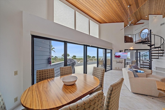 dining space featuring wooden ceiling, high vaulted ceiling, stairway, plenty of natural light, and light tile patterned floors