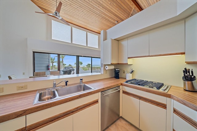 kitchen featuring appliances with stainless steel finishes, a sink, wood ceiling, light tile patterned floors, and high vaulted ceiling