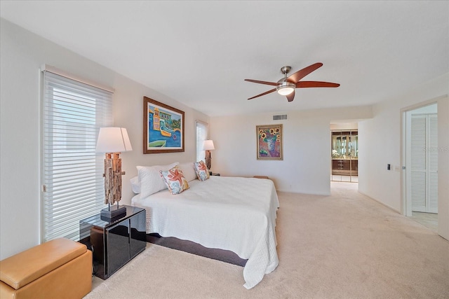bedroom featuring light colored carpet and a ceiling fan