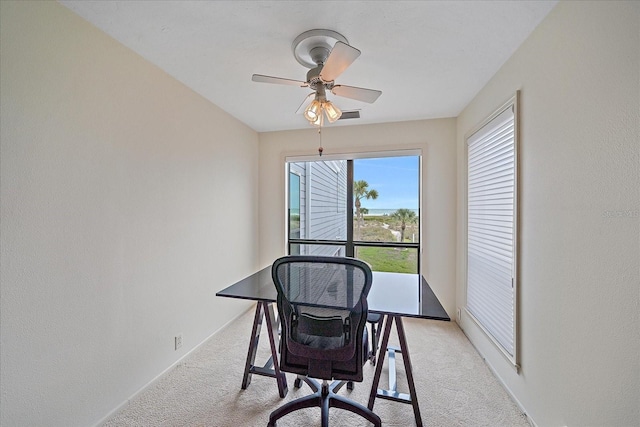 home office featuring light carpet and a ceiling fan