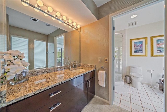 bathroom featuring baseboards, a stall shower, toilet, vanity, and tile patterned floors