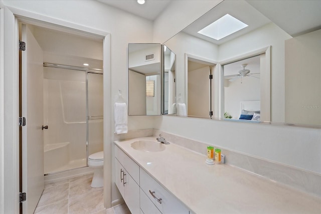 full bath featuring a skylight, a stall shower, toilet, and vanity