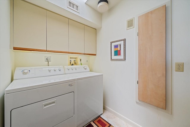 washroom with cabinet space, washer and clothes dryer, and baseboards