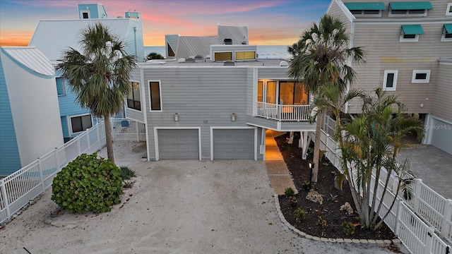 beach home featuring a garage, driveway, and fence