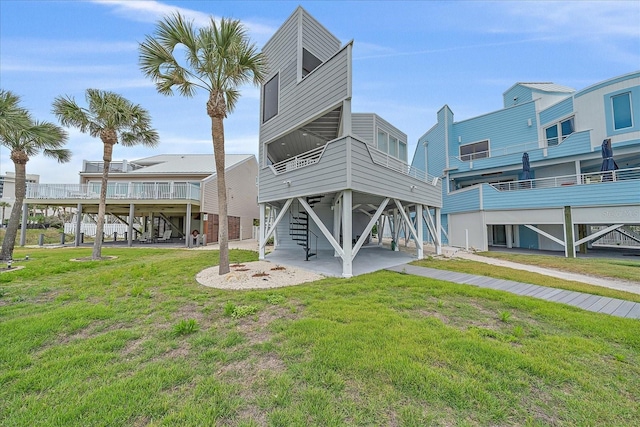 back of property with stairway, a yard, and a deck