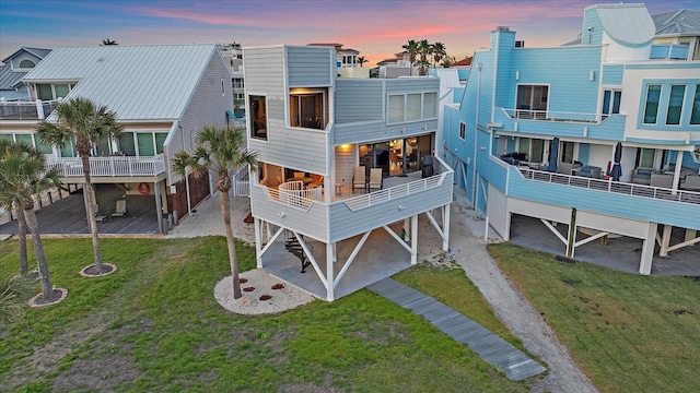 back of house featuring a carport, a lawn, and a residential view