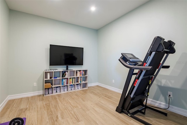 exercise room featuring baseboards and wood finished floors