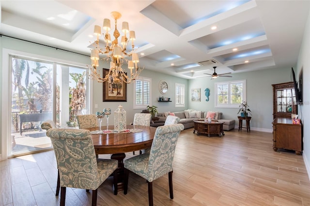 dining room with light wood-style floors, coffered ceiling, ceiling fan with notable chandelier, and a wealth of natural light