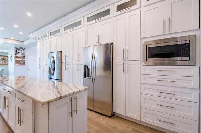 kitchen with a center island, light stone countertops, white cabinets, stainless steel appliances, and recessed lighting