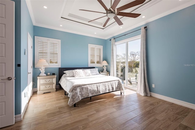 bedroom with a tray ceiling, access to exterior, wood finished floors, and ornamental molding