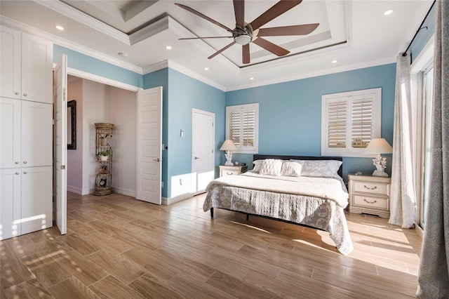 bedroom with recessed lighting, light wood finished floors, baseboards, and a tray ceiling
