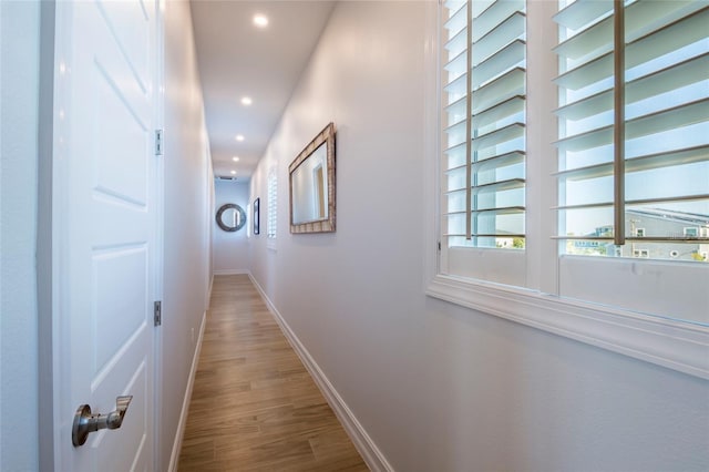 hall featuring recessed lighting, baseboards, and wood finished floors