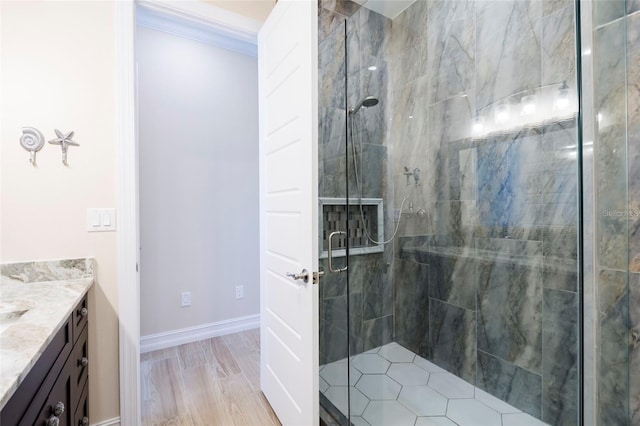 full bathroom with vanity, ornamental molding, baseboards, and a shower stall