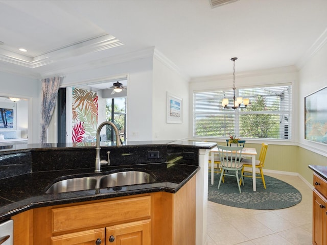 1313 Thornapple Dr, Osprey, FL 34229 - kitchen featuring ornamental molding, a healthy amount of sunlight, dark stone counters, and a sink