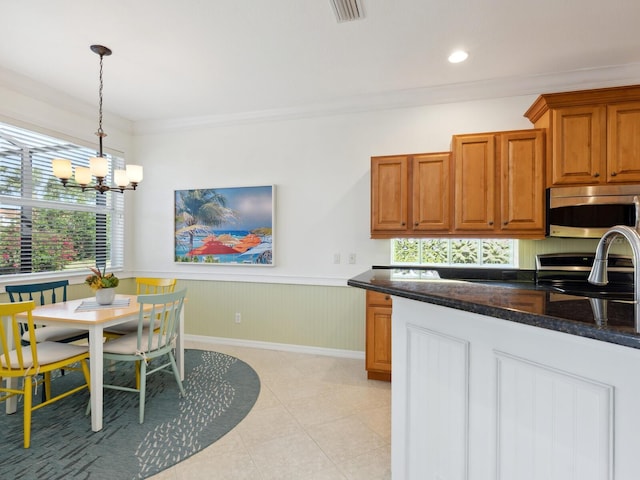1313 Thornapple Dr, Osprey, FL 34229 - kitchen featuring stainless steel appliances, a chandelier, wainscoting, plenty of natural light, and crown molding