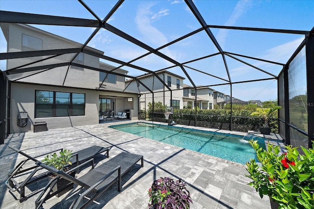 outdoor pool featuring a patio and glass enclosure