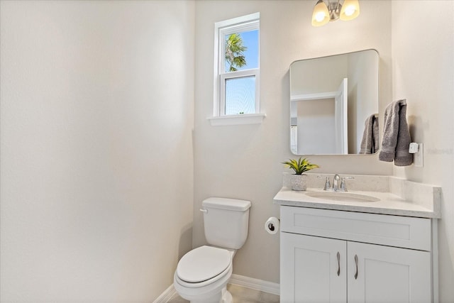 half bath with vanity, baseboards, and toilet