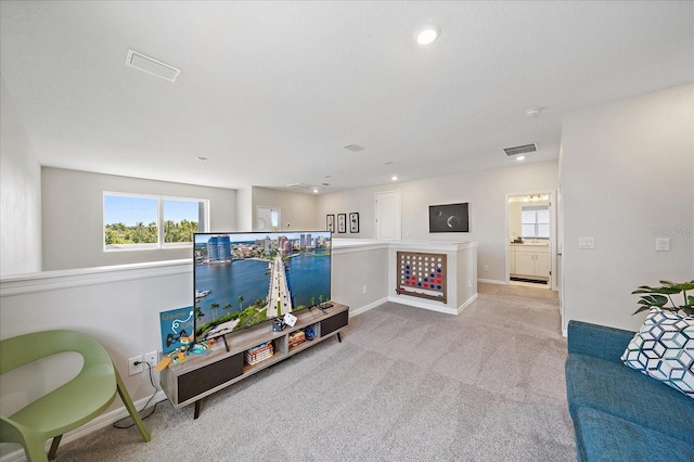 carpeted living area with visible vents, recessed lighting, and a healthy amount of sunlight