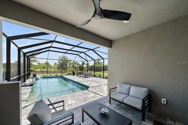 pool with ceiling fan, a lanai, an outdoor hangout area, and a patio area