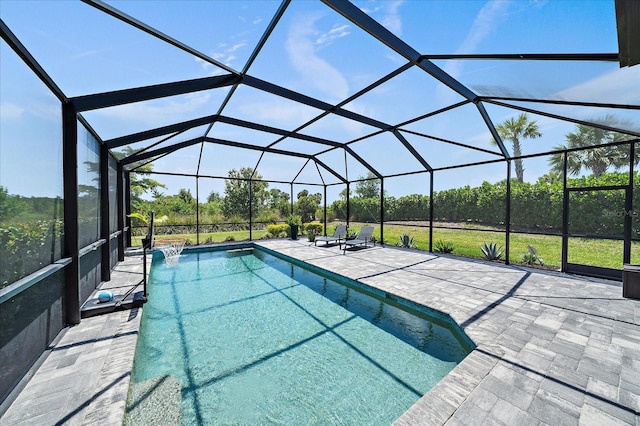 outdoor pool featuring glass enclosure and a patio