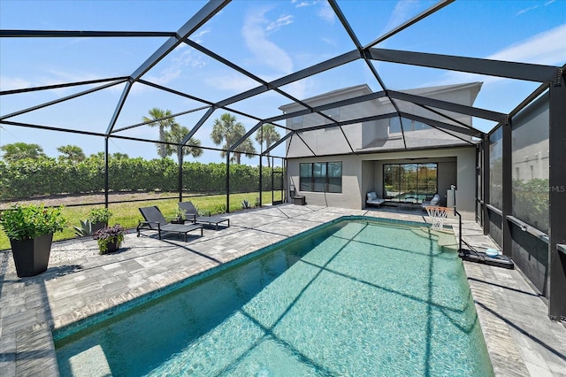 pool featuring glass enclosure and a patio area