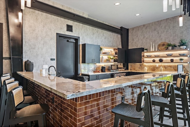 bar featuring backsplash, visible vents, and a sink