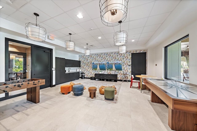 interior space with a paneled ceiling and an accent wall