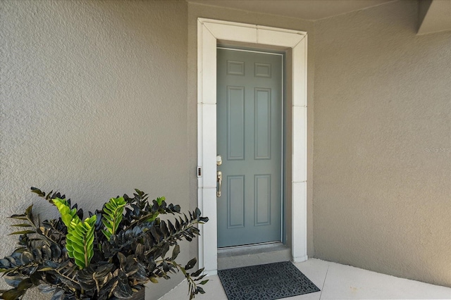 entrance to property with stucco siding