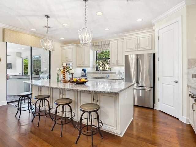 2525 Vaccaro Dr, Sarasota, FL 34231 - kitchen featuring freestanding refrigerator, ornamental molding, dark wood-style floors, a center island, and a notable chandelier
