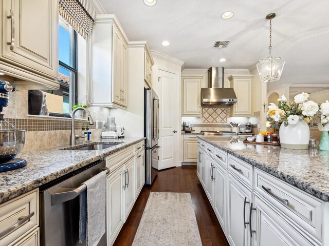 2525 Vaccaro Dr, Sarasota, FL 34231 - kitchen with wall chimney range hood, decorative backsplash, visible vents, appliances with stainless steel finishes, and a sink