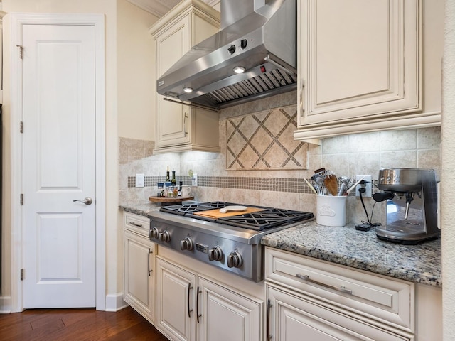 2525 Vaccaro Dr, Sarasota, FL 34231 - kitchen with tasteful backsplash, light stone countertops, stainless steel gas stovetop, wall chimney exhaust hood, and dark wood-type flooring