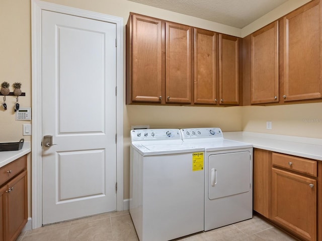 2525 Vaccaro Dr, Sarasota, FL 34231 - laundry room featuring cabinet space, washing machine and dryer, and light tile patterned flooring