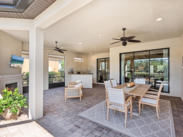 2525 Vaccaro Dr, Sarasota, FL 34231 - view of patio with ceiling fan, a lit fireplace, area for grilling, and outdoor dining space
