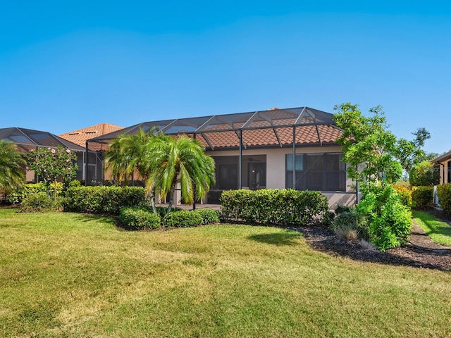 2525 Vaccaro Dr, Sarasota, FL 34231 - back of property with a lawn, stucco siding, and glass enclosure