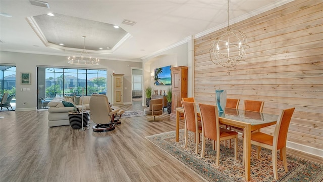 8713 Mangilli Rd, Sarasota, FL 34238 - dining area with a chandelier, wood finished floors, a tray ceiling, baseboards, and crown molding