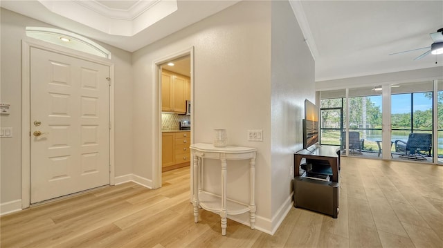 entrance foyer with light wood-style floors, a ceiling fan, baseboards, and crown molding