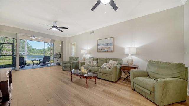 living room featuring a ceiling fan, visible vents, and light wood-style floors