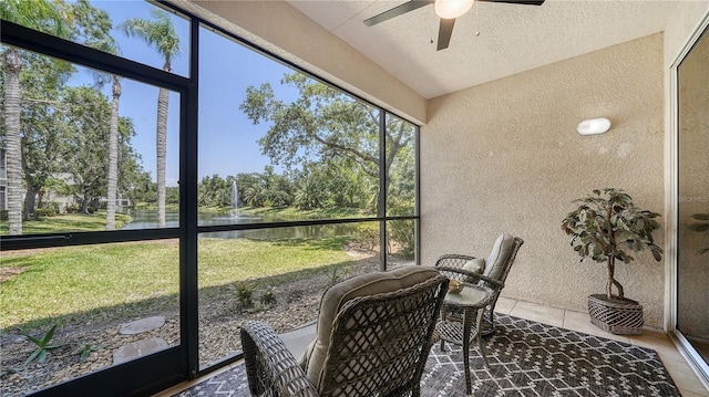 sunroom with a water view and ceiling fan