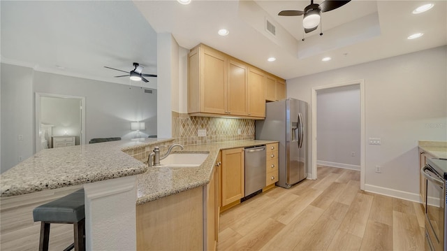 kitchen with a sink, appliances with stainless steel finishes, ceiling fan, and light brown cabinets