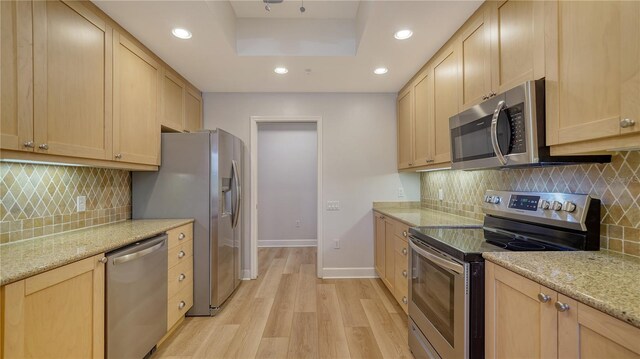 kitchen featuring appliances with stainless steel finishes, baseboards, light brown cabinets, recessed lighting, and light wood-style flooring